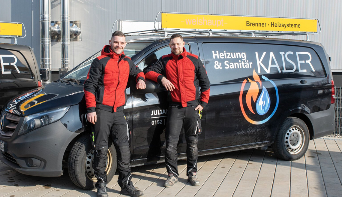 Zwei Mitarbeiter von Kaiser Heizungs- und Sanitärdiensten stehen neben einem Firmenfahrzeug.